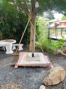a picnic table sitting next to a tree at ใจกลม โฮมคาเฟ่ in Ban Hua Phrong +1 photo