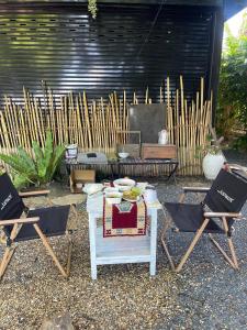 two chairs and a table in a yard with a table and two chairs at ใจกลม โฮมคาเฟ่ in Ban Hua Phrong