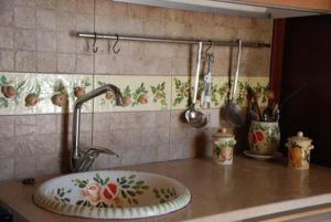 eine Küchentheke mit einer Spüle und Küchenutensilien in der Unterkunft Terrauzza Sul Mare di Renata Emmolo in Syrakus