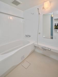 a white bathroom with a sink and a mirror at Red 28 in Ito