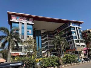 een groot gebouw met palmbomen ervoor bij SPOT ON SBL HOTEL ROOMS in Surat