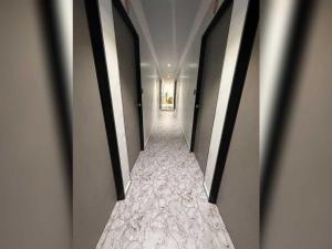 een hal met een lange gang met witte muren bij SPOT ON SBL HOTEL ROOMS in Surat