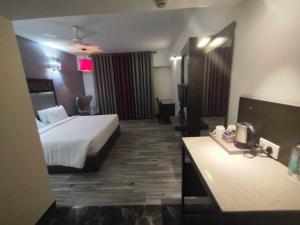 une chambre d'hôtel avec un lit et une salle de bain dans l'établissement POP 84200K M K Elegance Inn, à Coimbatore (Peelamedu)