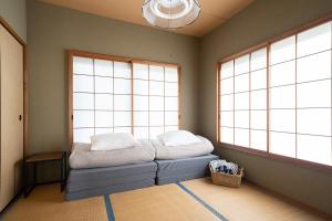 a room with a bed in front of two windows at Vacation Rental NENBA in Hokuto