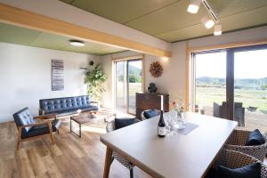 a living room with a table and a couch at Vacation Rental NENBA in Hokuto
