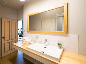 a bathroom with a white sink and a mirror at Vacation Rental NENBA in Hokuto +12 photos
