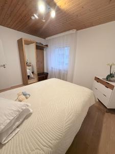 a bedroom with a large white bed and a mirror at FerienwohnungNord in Singen +2 photos