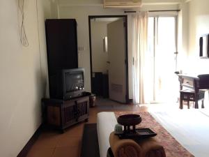 een woonkamer met een bank en een tv bij Baan Pim in Chiang Mai