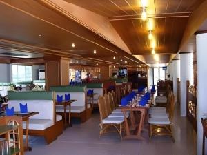 un restaurant avec des tables et des chaises et des serviettes bleues dans l'établissement Pailyn Hotel, à Sukhothaï