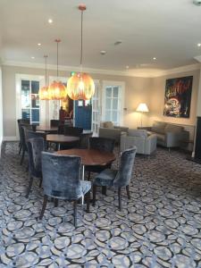 a dining room with tables and chairs and a couch at Park Inn by Radisson Shannon Airport in Shannon
