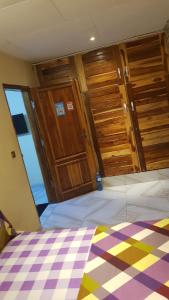 una camera da letto con porte in legno e un letto con pavimento a scacchi di Résidence Yamoussoukro a Yamoussoukro