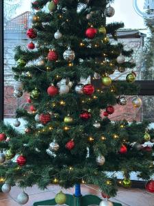 een kerstboom met kerstversieringen erop bij Akme APARTMENTS & ROOMS & FREE PARKING in Gdańsk