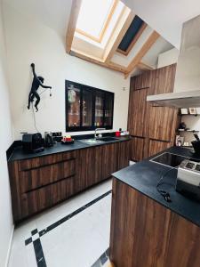 a kitchen with wooden cabinets and a person jumping on the counter at Le Capella, magnifique maison au calme avec garage in Caen