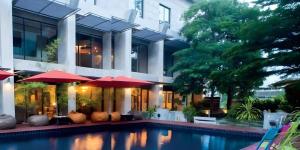 une maison avec une piscine avec des parasols rouges dans l'établissement Klim Hotel, à Buriram