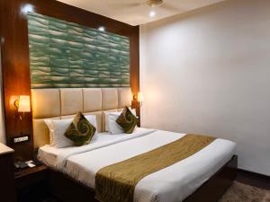 een hotelkamer met een bed met een schilderij aan de muur bij Hemaadri Grand in Hyderabad