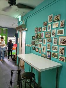 un mur bleu avec une table et deux tabourets dans l'établissement Royal Hostel Singapore, à Singapour