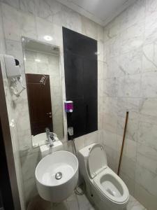 a bathroom with a white toilet and a sink at فندق أمل المشاعر in An Nikāshah