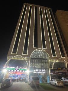 a building with cars parked in front of it at night at فندق أمل المشاعر in An Nikāshah