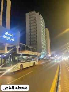 a bus driving down a city street at night at فندق أمل المشاعر in An Nikāshah
