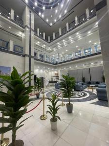 a lobby with potted plants in a building at فندق أمل المشاعر in An Nikāshah