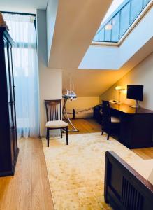 een zolderkamer met een bureau en een stoel bij Jurmaris in Neringa