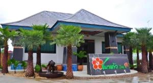 een huis met palmbomen ervoor bij Chabakaew Resort in Tha Maka