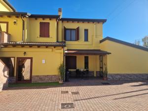 una casa gialla con un patio di fronte di Hotel IL Rifugio a Gonzaga