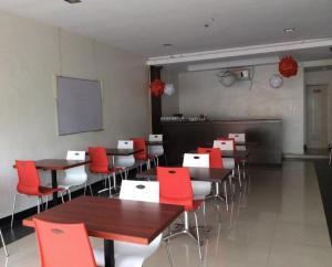 Bahac-bahacCherry Midtown Hotel的有桌子和红色椅子的餐厅