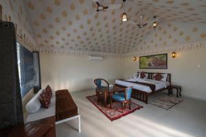 een slaapkamer met een bed, een tafel en stoelen bij Upvan Jawai - Unit of Dev Group in Bāli