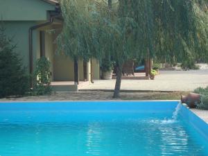 a blue swimming pool in front of a house at Toscana Villa in Snagov