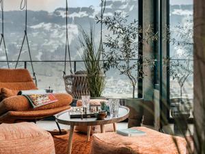 a room with a table and chairs and a large window at Hotel Sieghard Zillertal in Mayrhofen