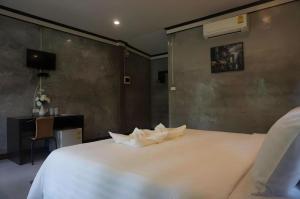 una camera da letto con un grande letto bianco e una scrivania di V Valley Resort a Satun Altre 128 foto