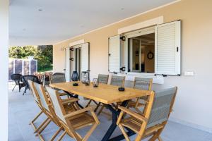 a wooden table and chairs on a patio at Casa Sorgente in Ágioi Doúloi