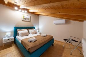 a bedroom with a bed with two towels on it at Casa Sorgente in Ágioi Doúloi