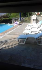 a row of lounge chairs next to a swimming pool at Casa delle Betulle in Verbania