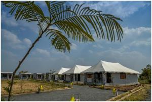 een rij witte tenten met een palmboom bij Upvan Jawai - Unit of Dev Group in Bāli