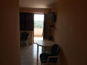 Zimmer mit einem Tisch, Stühlen und einem Fenster in der Unterkunft Apartments Mudrić in Herceg-Novi