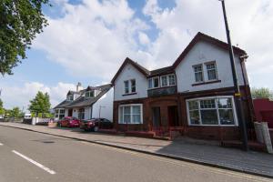 a white house on the side of a street at Norwood Guesthouse-Loch Lomond in Balloch