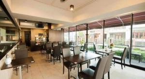 un restaurant avec des tables, des chaises et des fenêtres dans l'établissement Wsotel Hotel, à Ban Saphan Yao