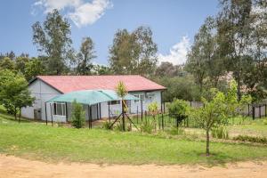 a small white house with a red roof at Forest View Cottage in Muldersdrift
