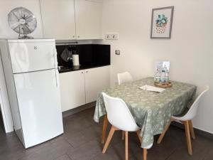 a kitchen with a table and a white refrigerator at Casina al Lago in Lavena Ponte Tresa
