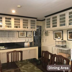 - une cuisine avec des placards blancs et un coin repas dans l'établissement Felicitas Tagaytay, à Tagaytay