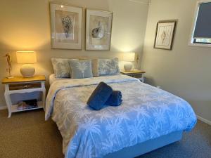 a bedroom with a blue bed with two night stands at Lakeview Cottage in Forster