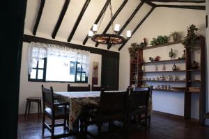 a dining room with a table and chairs and a chandelier at Finca Villa Sofía in Villa de Leyva