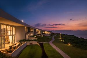 a building with a view of the ocean at night at Araqila in Vengurla