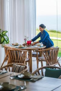 a woman sitting at a table in a restaurant at Araqila in Vengurla