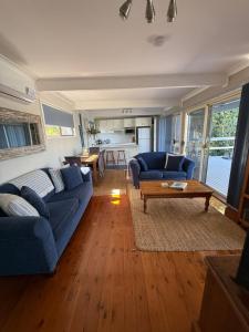 a living room with a blue couch and a table at Lakeview Cottage in Forster