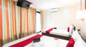 a hotel room with two beds and a television at Dino Residences in Daro