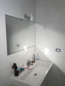 a white bathroom with a sink and a mirror at Casa Maria in Salerno