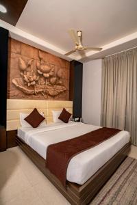 une chambre avec un grand lit et un tableau au mur dans l'établissement Namaste Khatu Shyam, à Khātu 59 autres photos